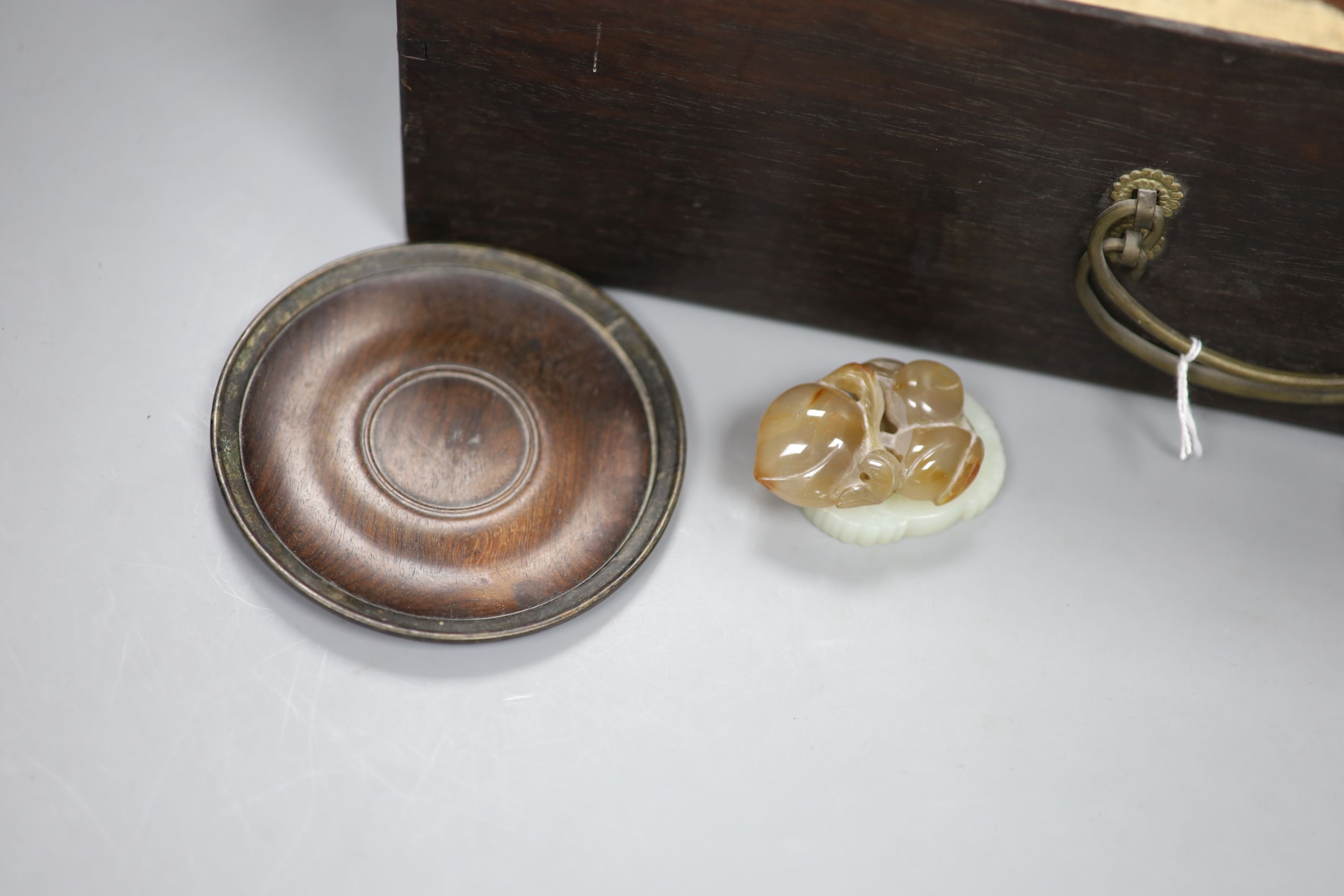 A pair of zitan wood saucers, c. 1800, a Japanese netsuke, c. 1900 an agate pendant of peaches, c.1900, a modern white jade pendant and